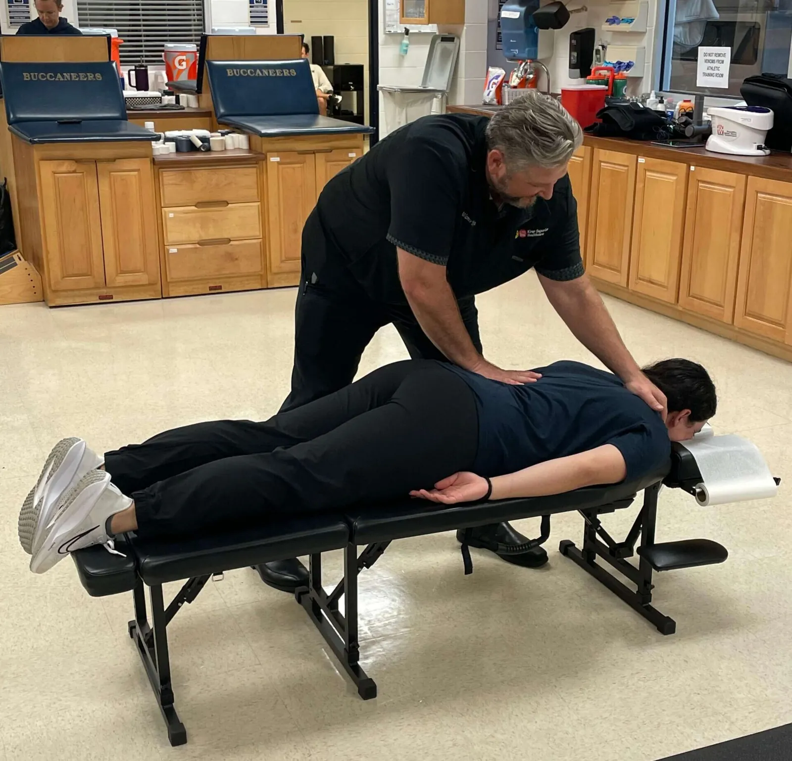 Chiropractor adjusting a patient's back on a portable table