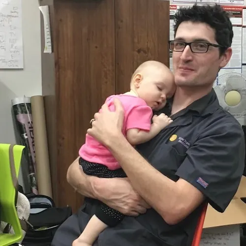 Chiropractor holding a baby during a pediatric visit