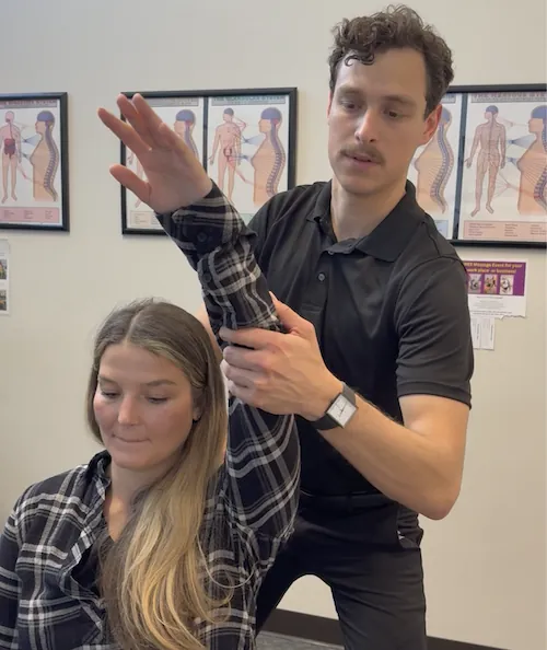 Dr. Kyle Ordille stretching a patient's arm and shoulder