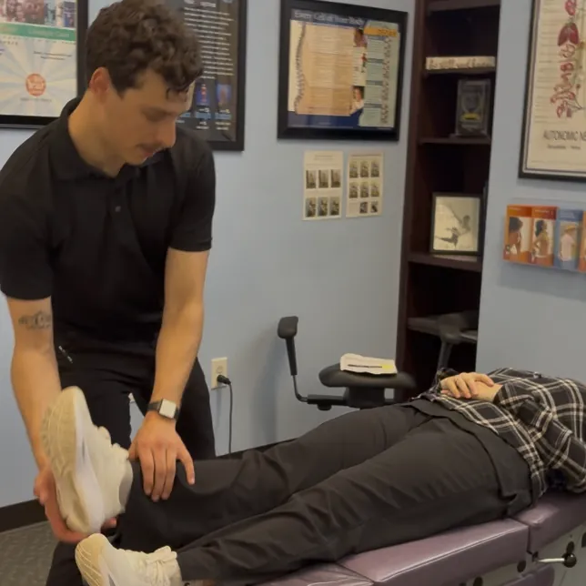 Dr. Kyle Ordille adjusting a patient's leg