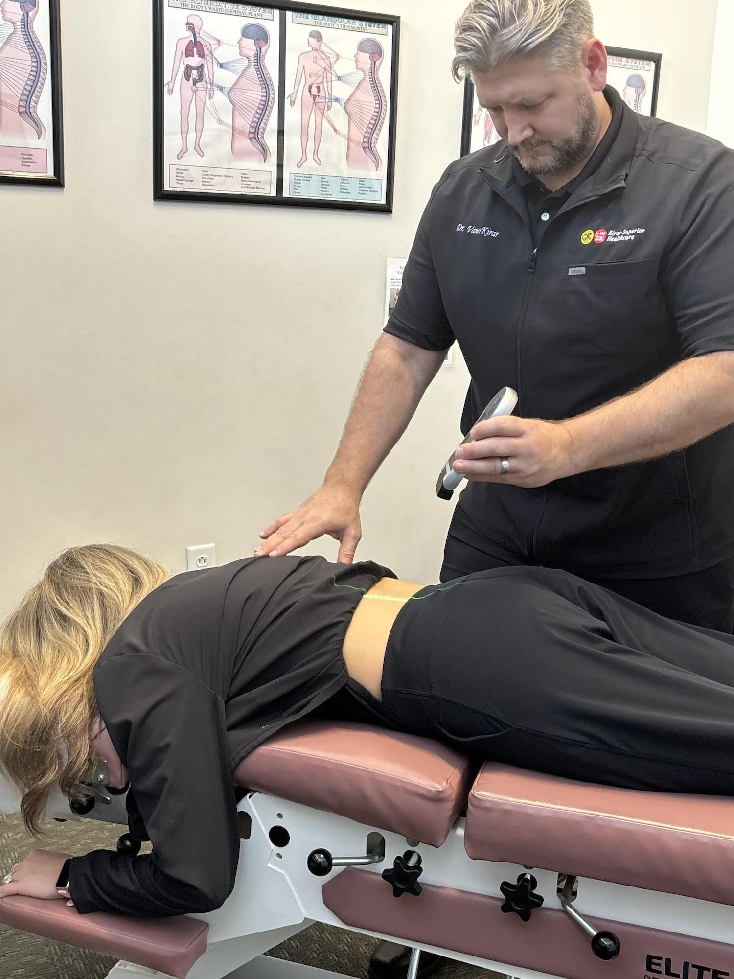 Dr. Vance Kirar giving laser therapy to a patient's back