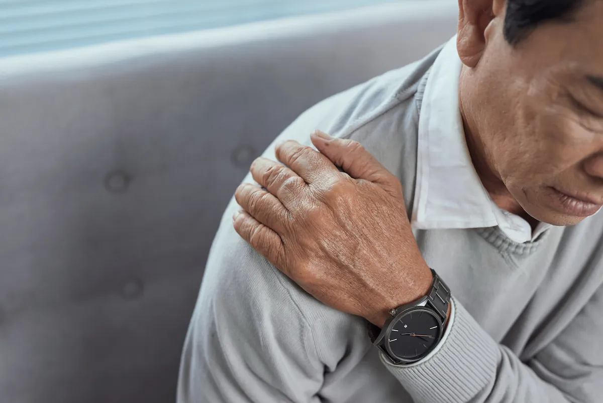 Older man holding his shoulder from bursitis pain
